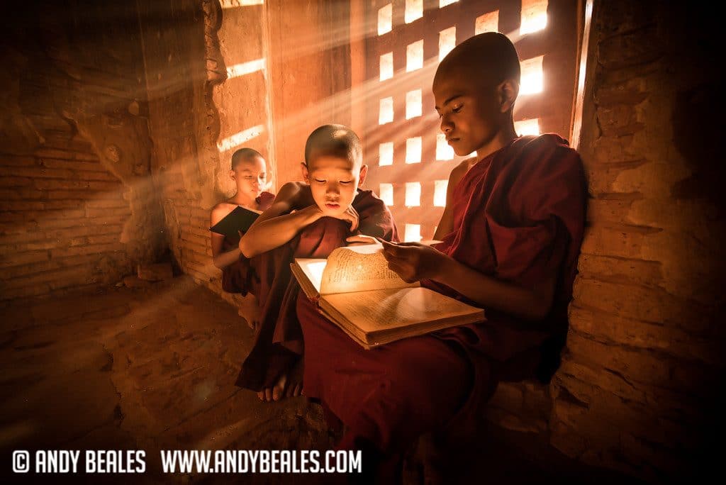 Monks reading in the light rays of a window in Myanmar Burma