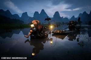 Guilin's cormorant fishermen reflecting on the calm Li River with their kerosine lamps in the dusk light.